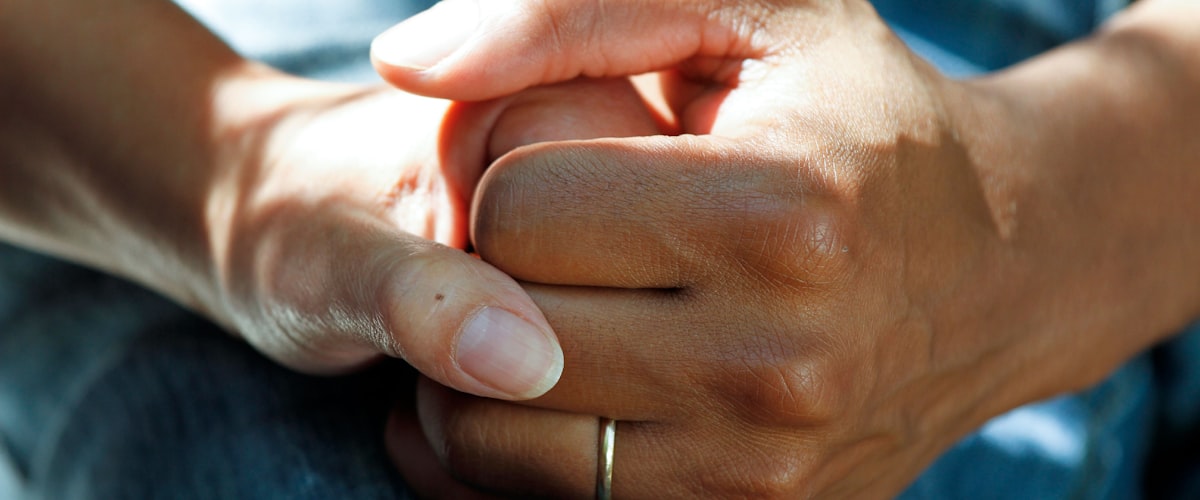 Pharmacist holding a patient's hands — caring, confidential support at Barons Court Pharmacy