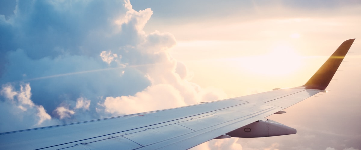 Aeroplane wing above the clouds — travel vaccinations and travel health advice at Barons Court Pharmacy